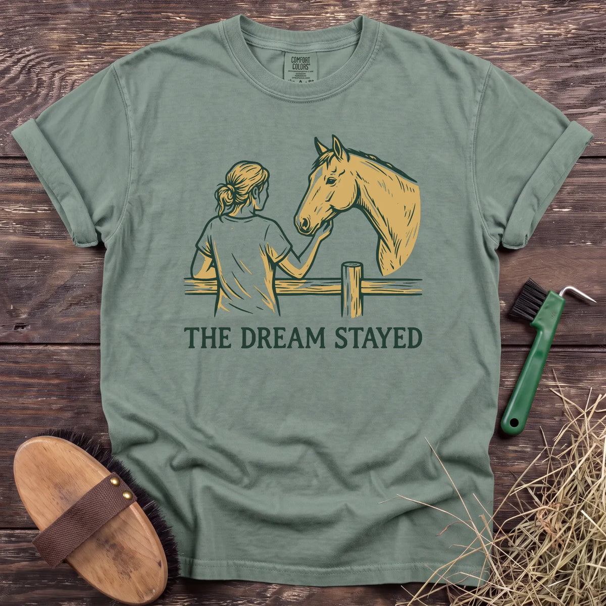 Light green t-shirt featuring a graphic of a person with a horse and the text "THE DREAM STAYED." Perfect for horse lovers.