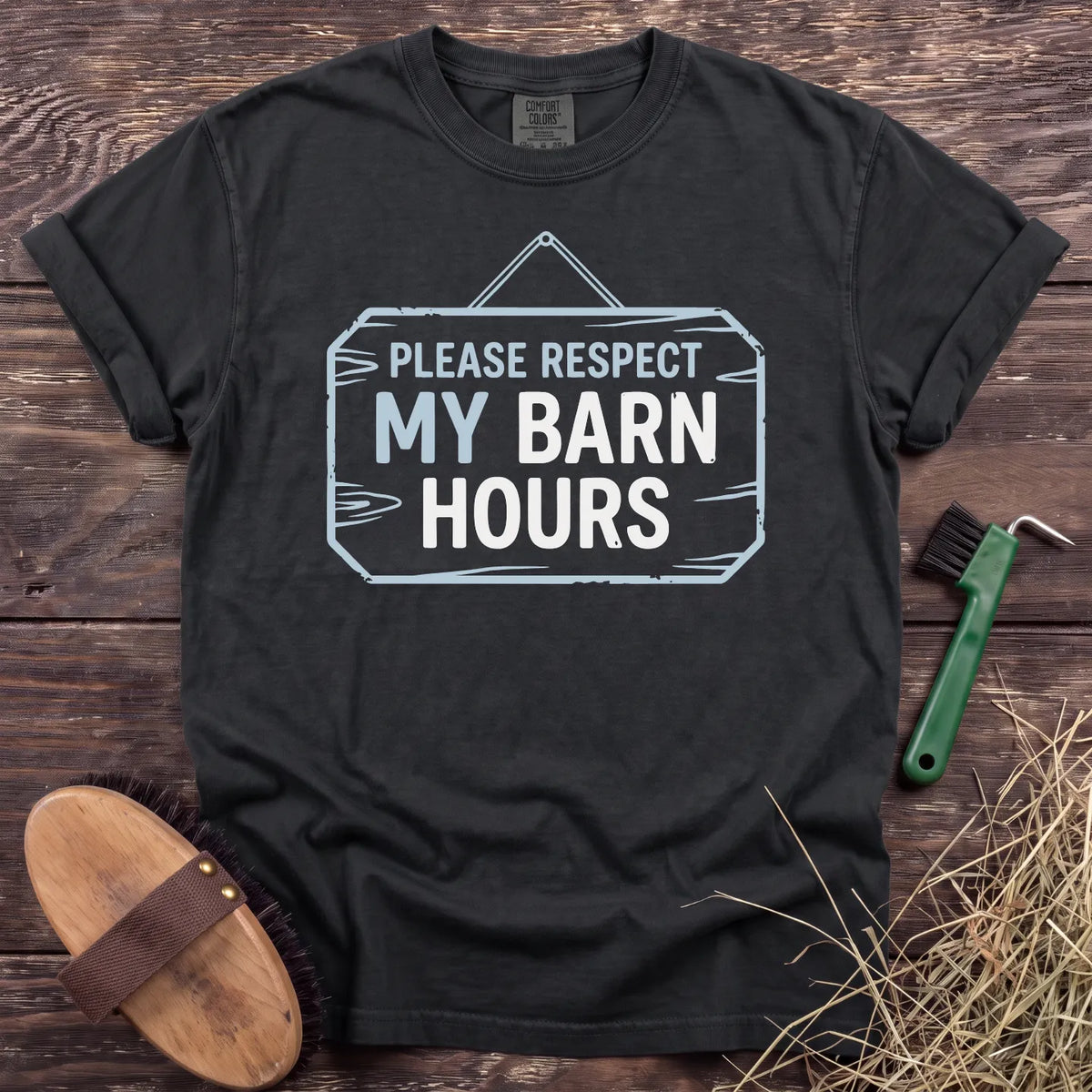Respect My Barn Hours T-Shirt in Black, front view on a wooden barn surface. [color: Black]