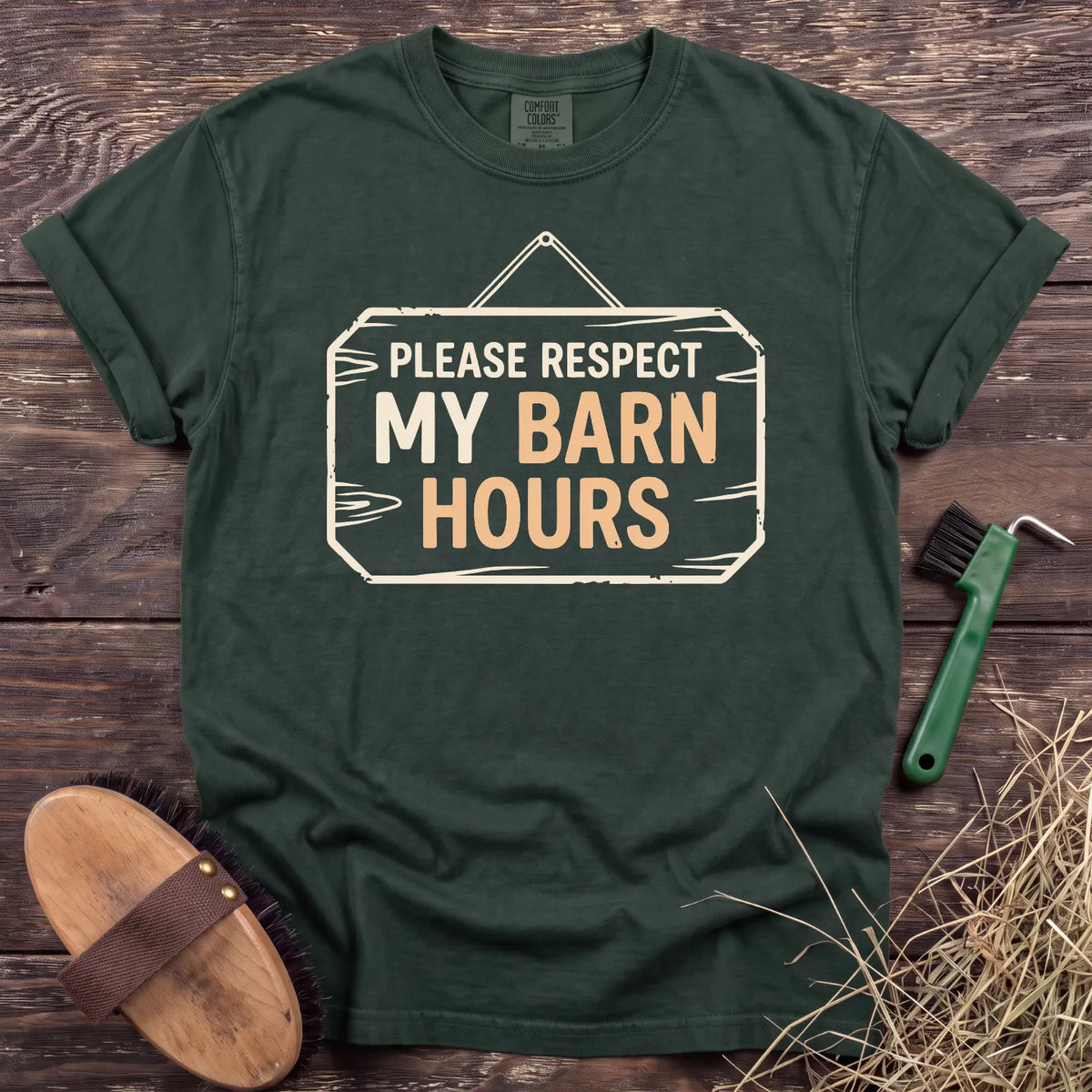Respect My Barn Hours T-Shirt in Moss, front view on a wooden barn surface. [color: Moss]